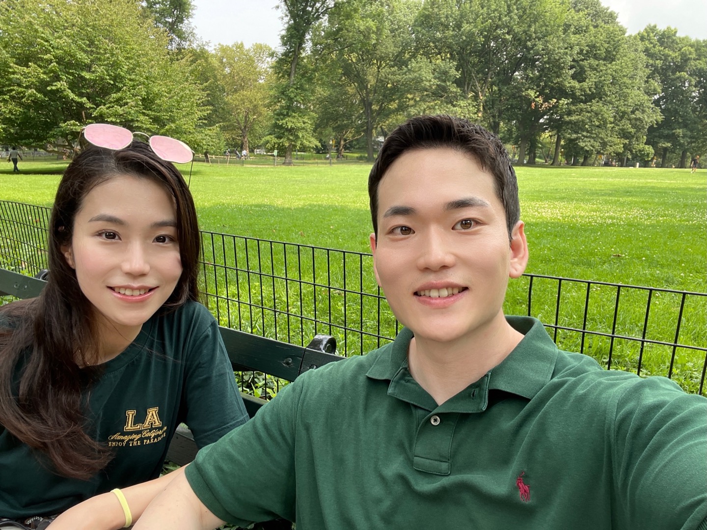 Jex and Hanna smiling together on a park bench.